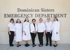 Nurses, sisters and staff standing in front of St. Dominic's ER sign